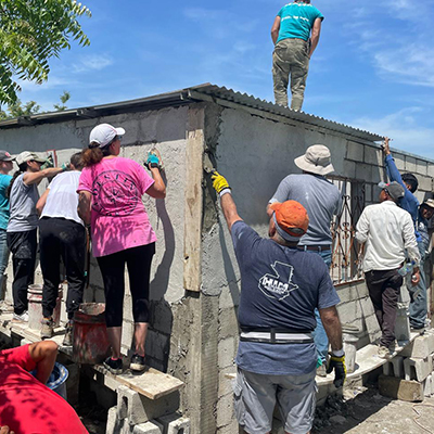 St. Patrick Youth Ministry finishing the stucco work on the outside of a home built and funded by Hearts In Motion.