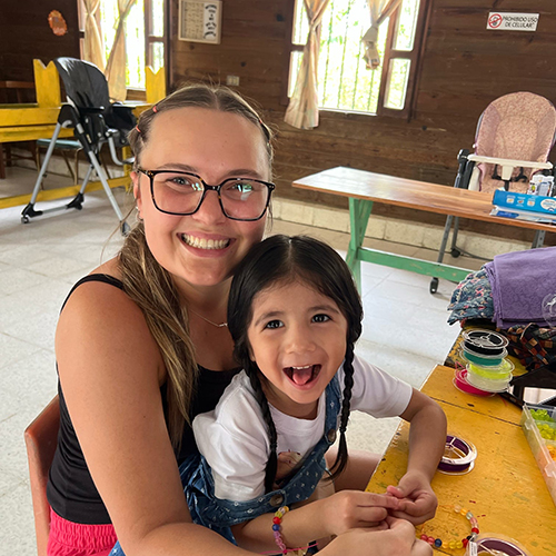 University of Idaho student with child at the Gualan nutrition center.