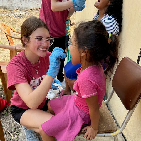 Washington State University student providing dental varnish to help protect a child's teeth.