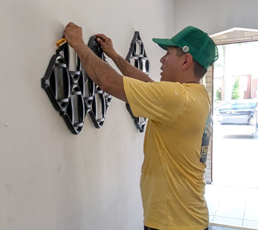 Hanging artwork in a newly furnished apartment that was furnished by the New Directions Program.