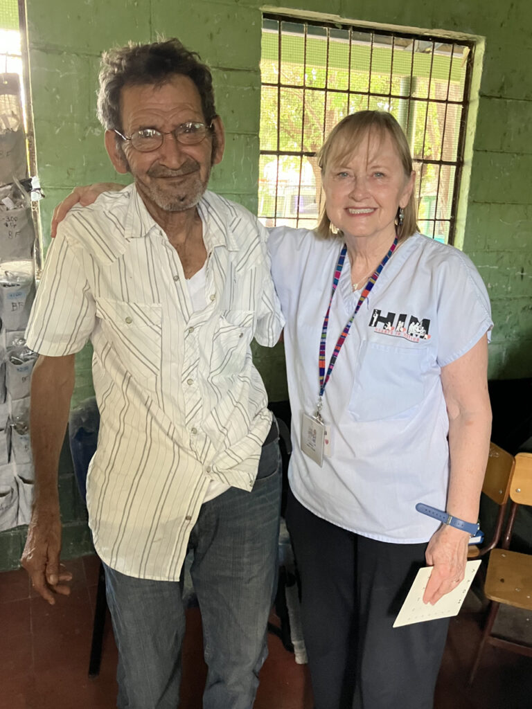 Marcia McGinnis at a pop up clinic with a patient providing vision care.