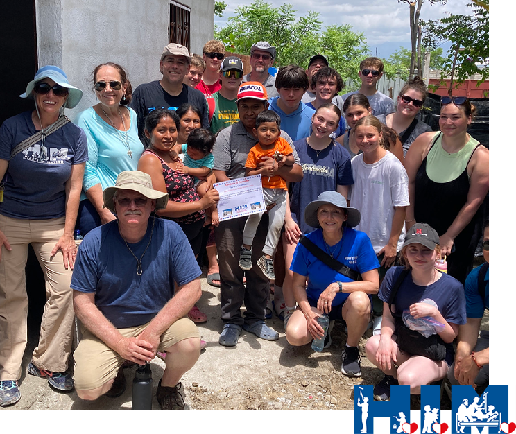 St. Patrick Youth Ministry presenting a certificate and keys to a family in Pueblo Modelo, Guatemala of a home they just built.