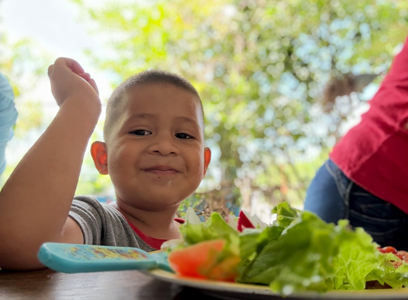 Sponsorship child enjoying their food at the weekly feed program at the HIM nutrition center in Gualan, Guatemala.