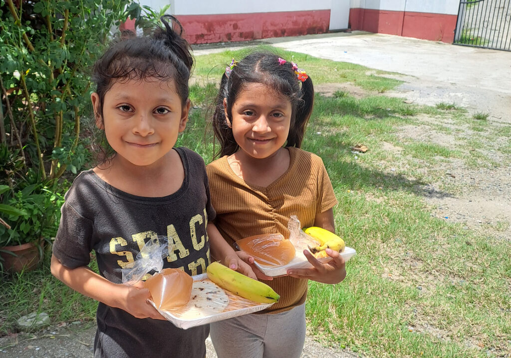 Two sponsorship children receiving their food at the weekly feed program at the HIM nutrition center in Gualan, Guatemala.