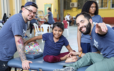 Two therapy students with child patient in pop up clinic- Guatemala